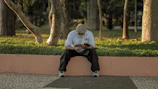 A reader deeply engaged with the equilibratumente book in a peaceful park setting.