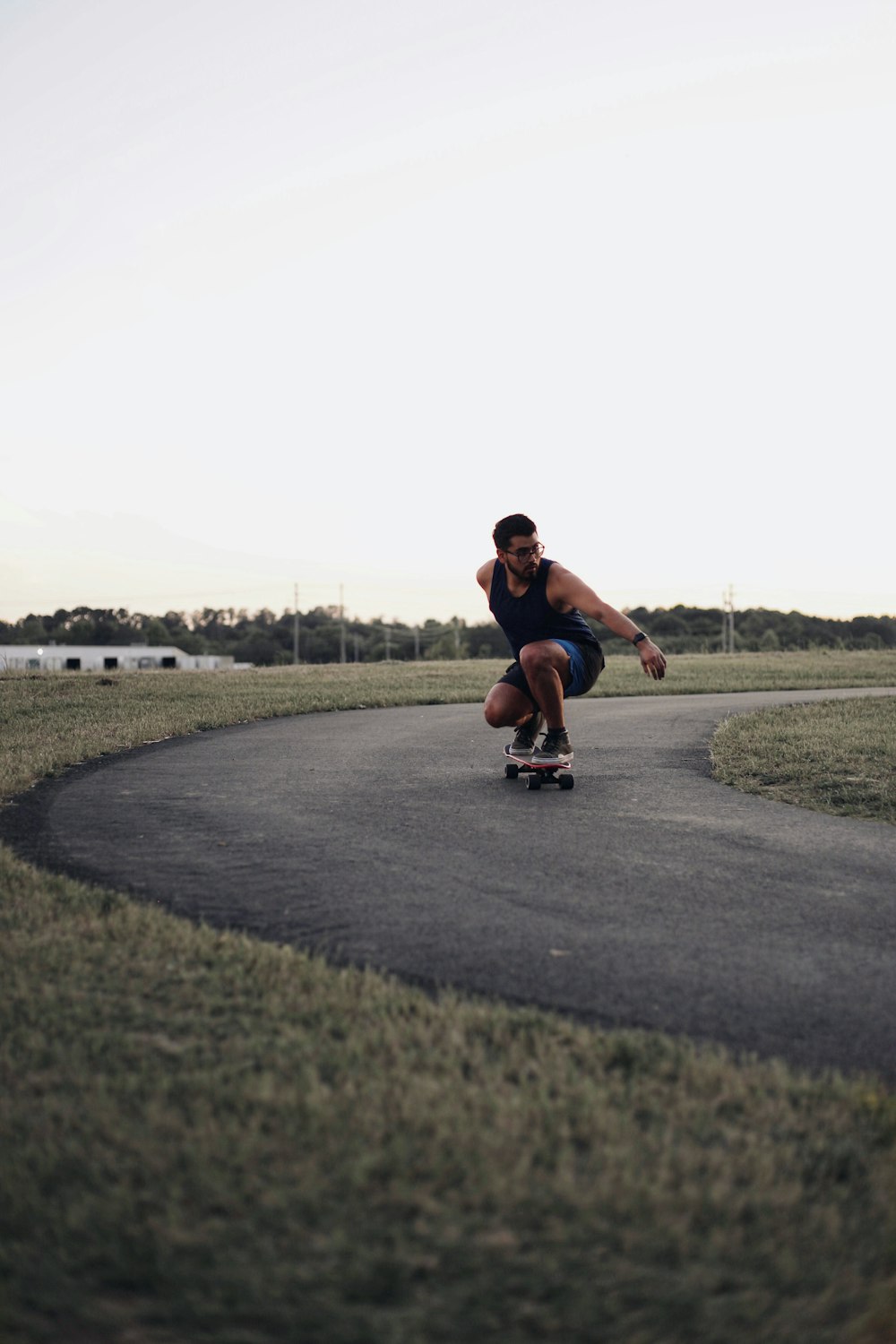 man in red t-shirt and black shorts riding skateboard during daytime