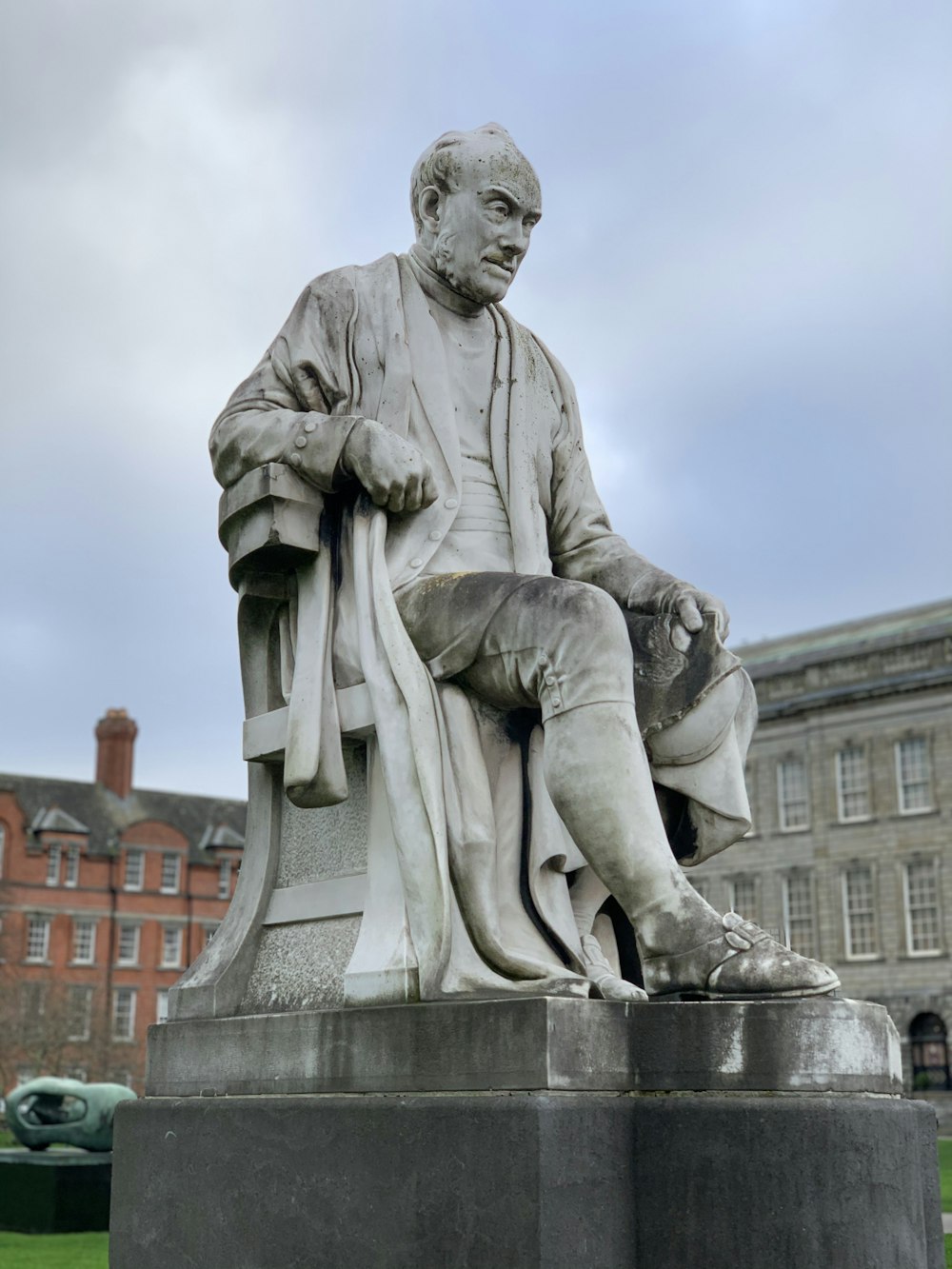 statue of man holding book