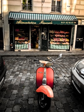 Vintage Piaggio Ape triporteur decorated with Sicilian cart motifs parked in a sunny Aix-en-Provence street.
