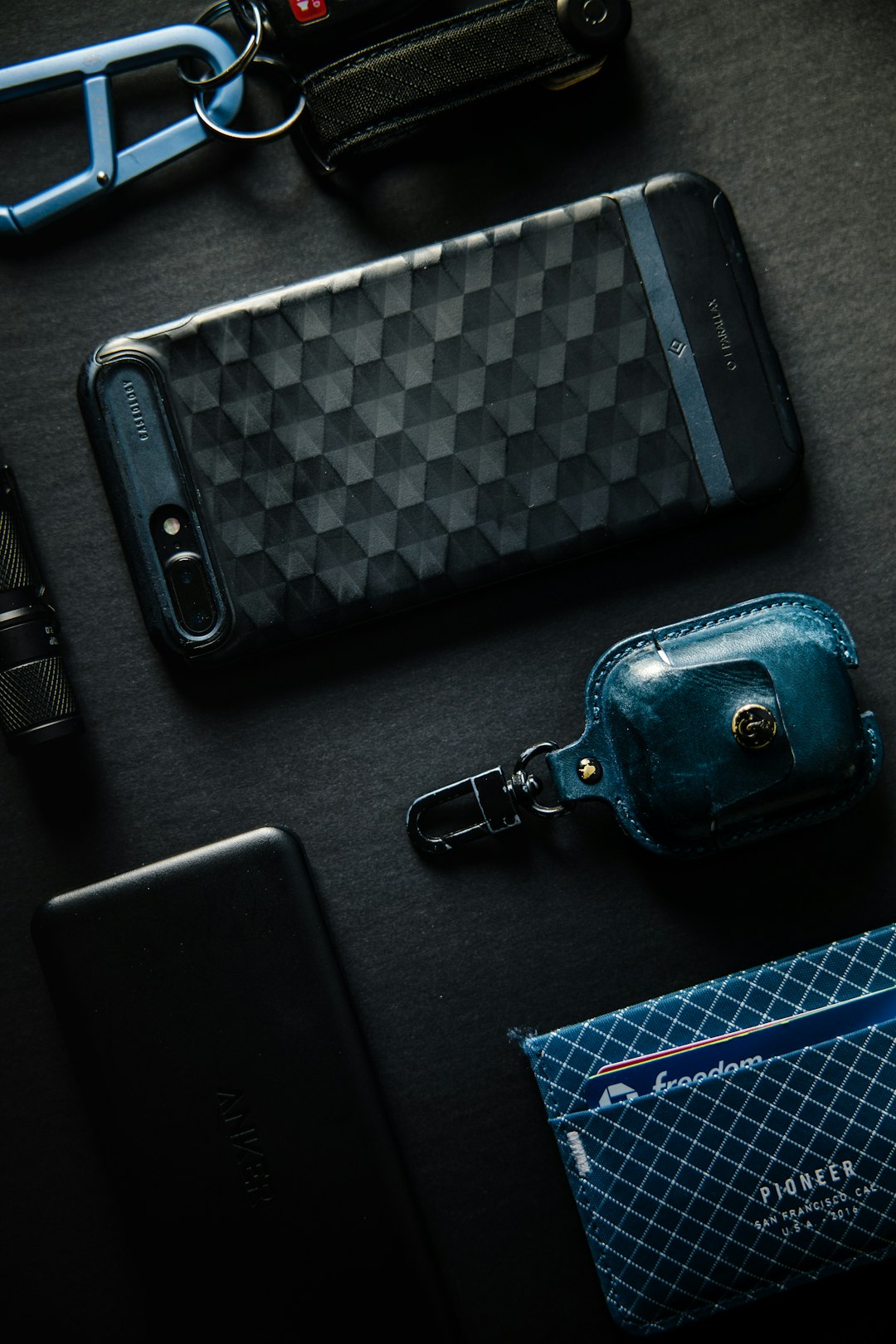 black leather bag beside black smartphone case