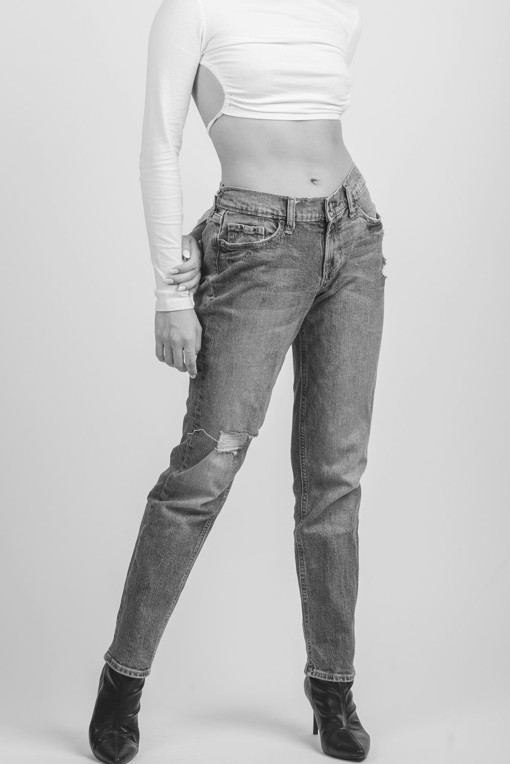 grayscale photo of woman in white long sleeve shirt and black denim jeans