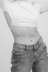 A casual outfit featuring a modern conjunto with a cropped top and matching pants in soft tones.