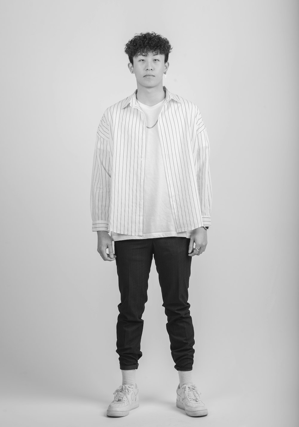 Foto Hombre con camisa de vestir a rayas blancas y negras y pantalones  negros – Imagen Gris gratis en Unsplash