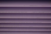 Several purple PVC pipes with black text printed on them. The text includes specifications and a caution that the water is not for drinking.