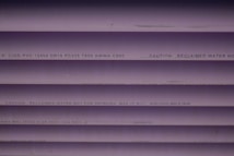 Several purple PVC pipes with black text printed on them. The text includes specifications and a caution that the water is not for drinking.
