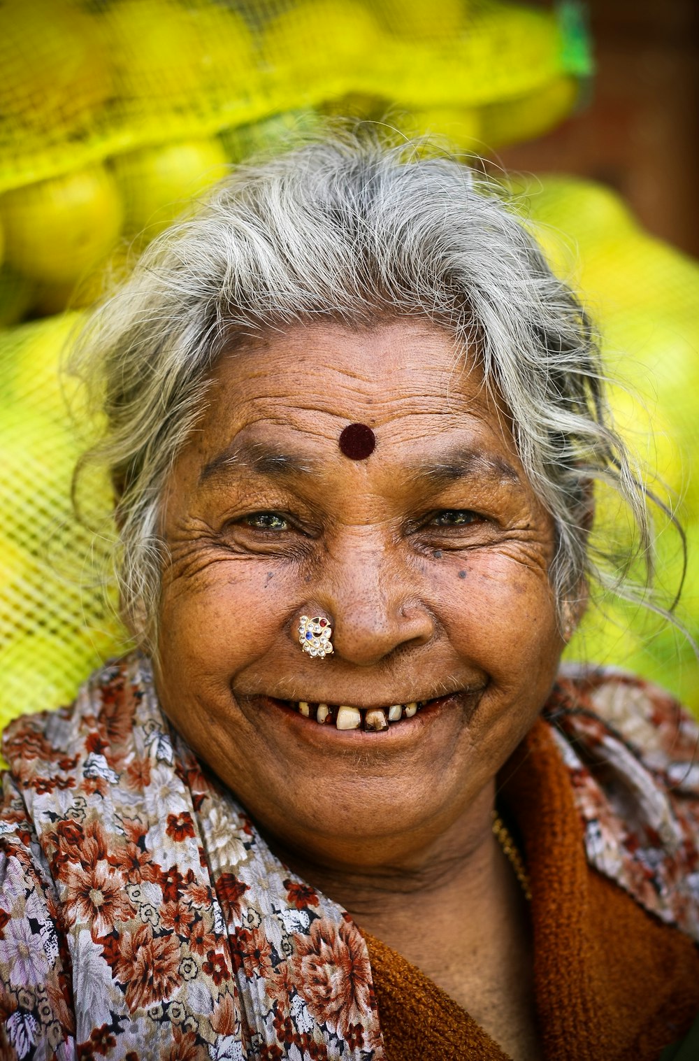 woman in white red and blue floral shirt smiling