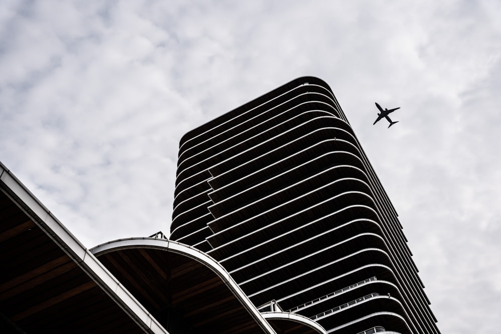 airplane flying over the building during daytime