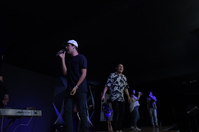 A diverse choir singing passionately with piano accompaniment on stage.