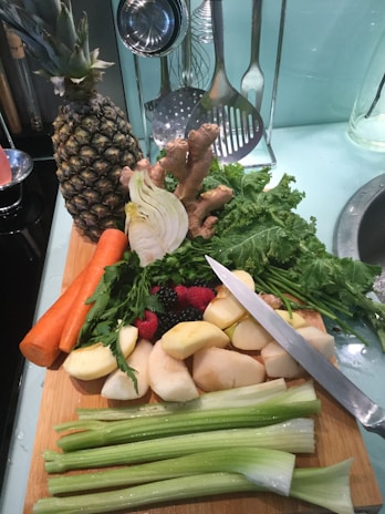 Freshly sliced fruits and vegetables arranged artistically on a cutting board ready for juicing.