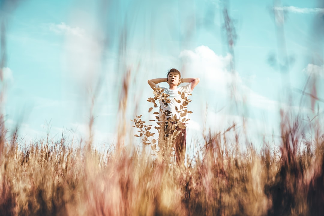 girl in white dress standing on brown grass field during daytime