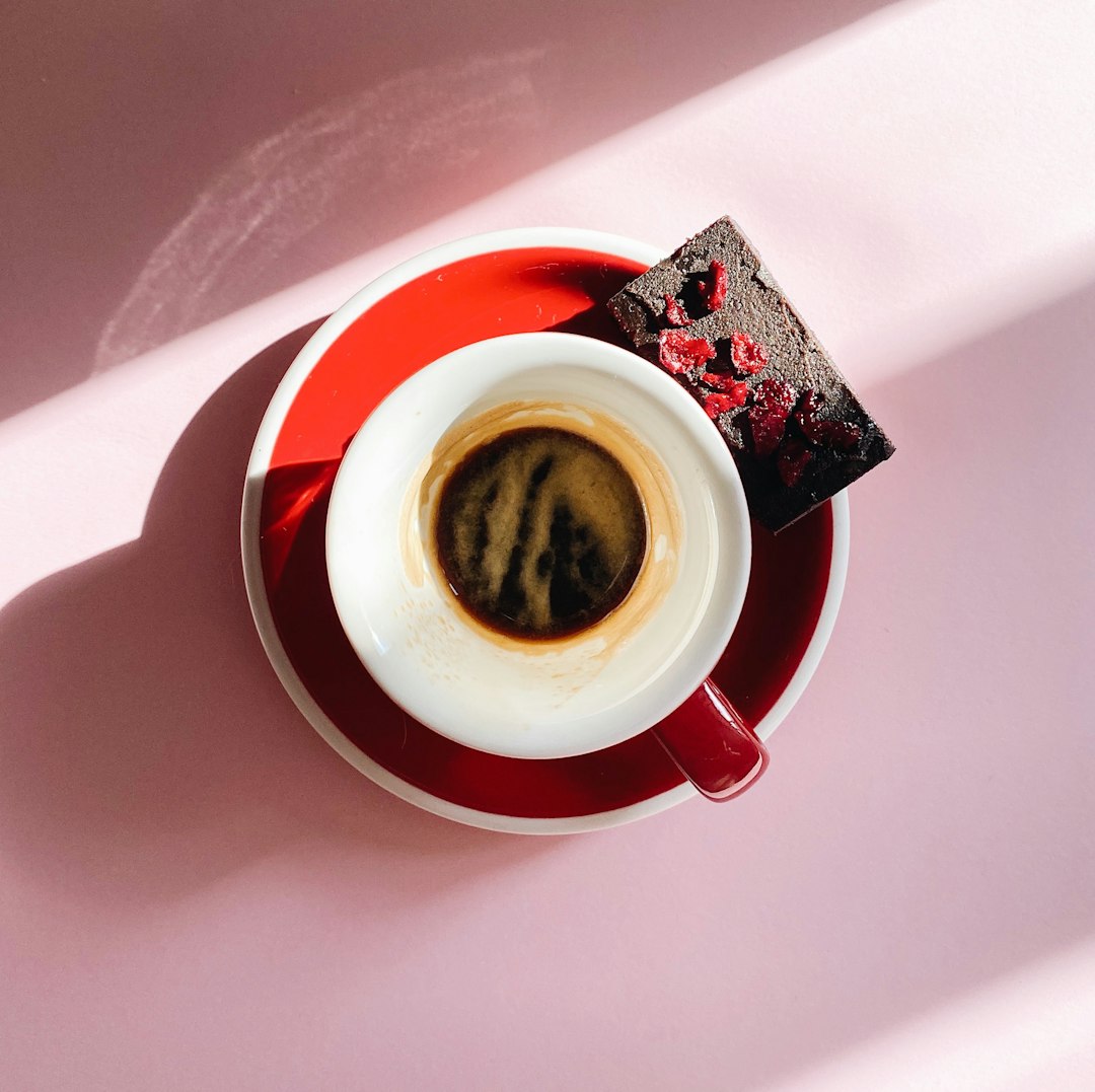 white and red ceramic mug with coffee