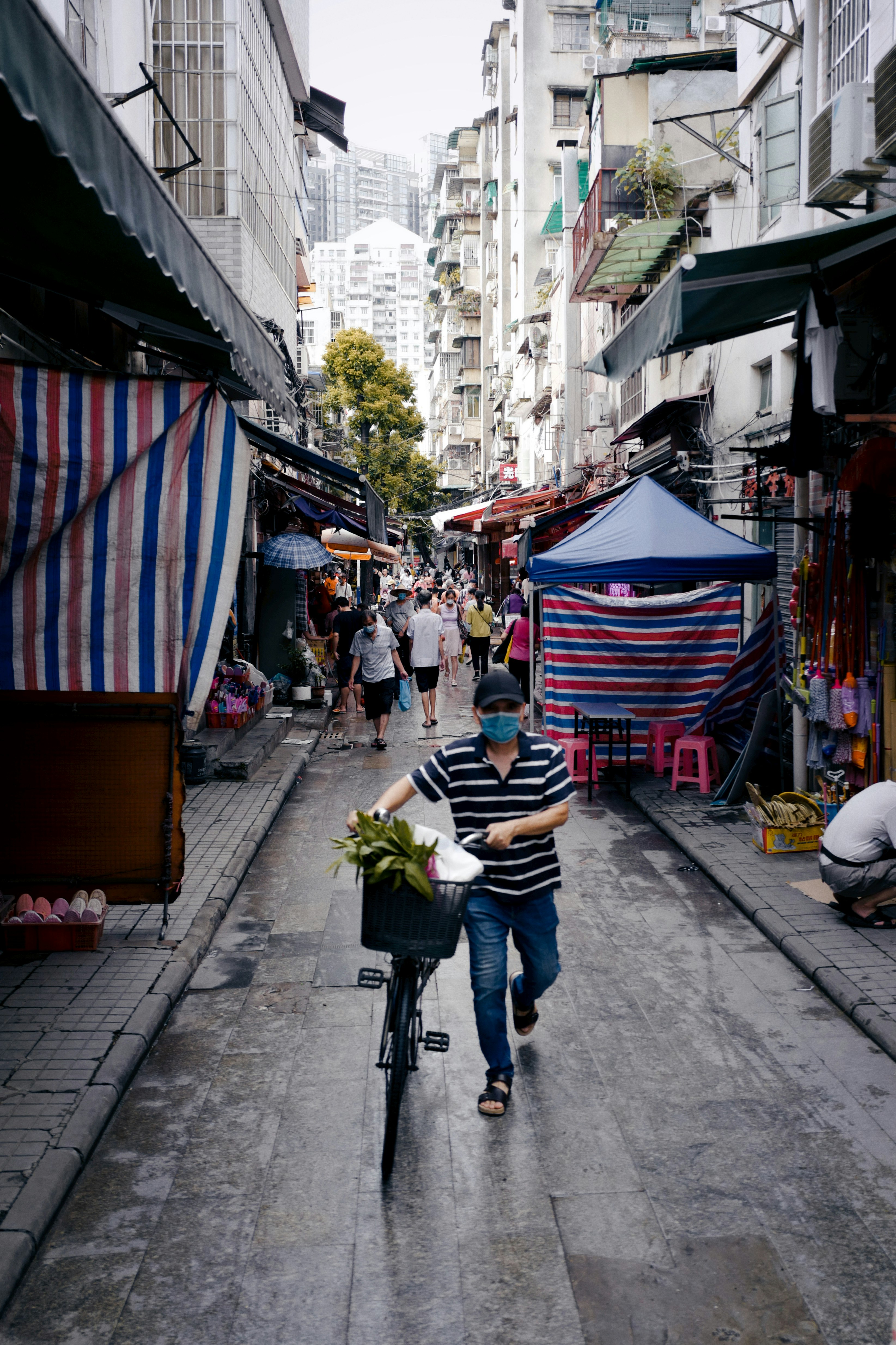 woman in blue denim jeans and white and black striped shirt walking on sidewalk during daytime