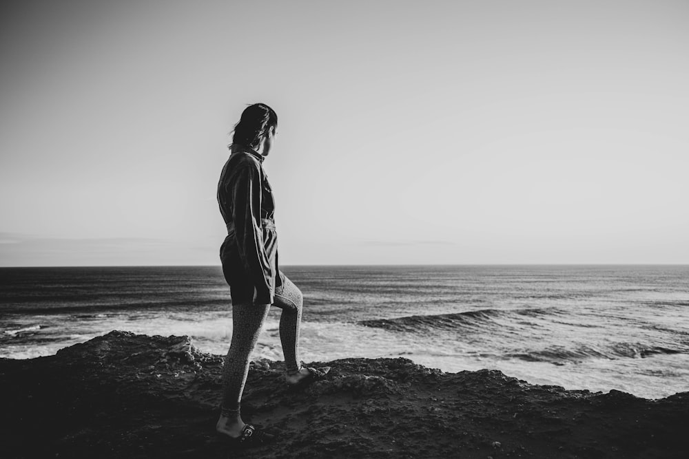 woman in black long sleeve shirt standing on beach shore
