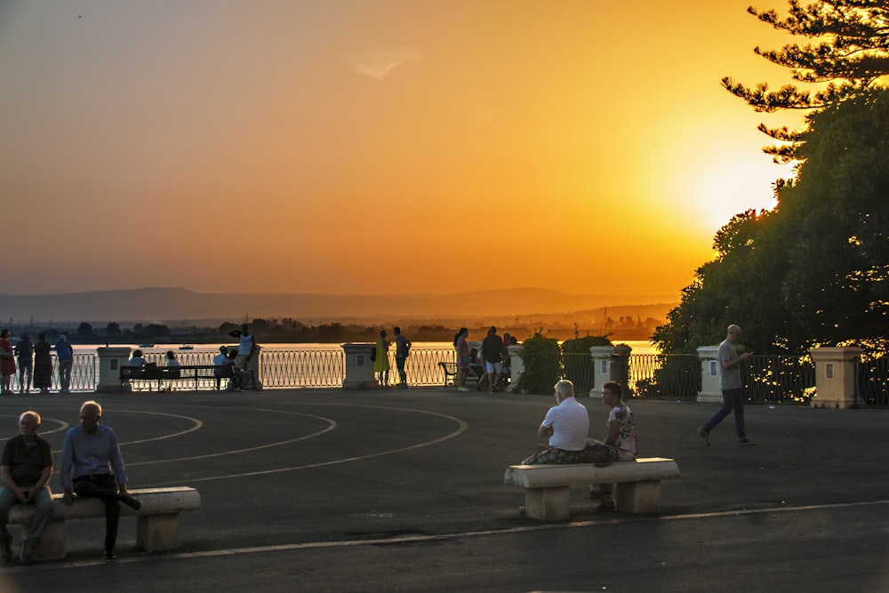 Gente sentada en el banco durante la puesta del sol