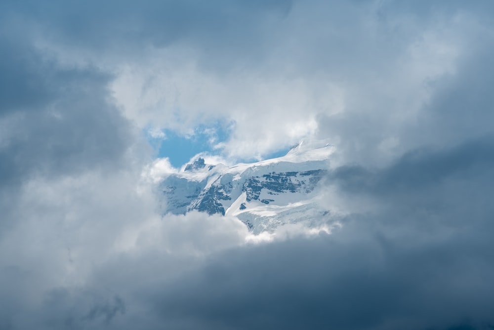 white clouds over snow covered mountain