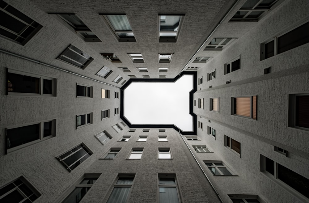 low angle photography of high rise buildings under white clouds during daytime