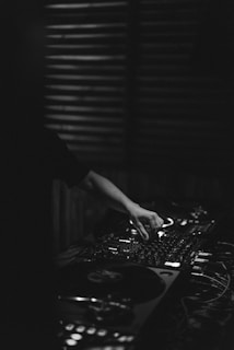 A DJ mixing tracks on turntables in a dimly lit studio