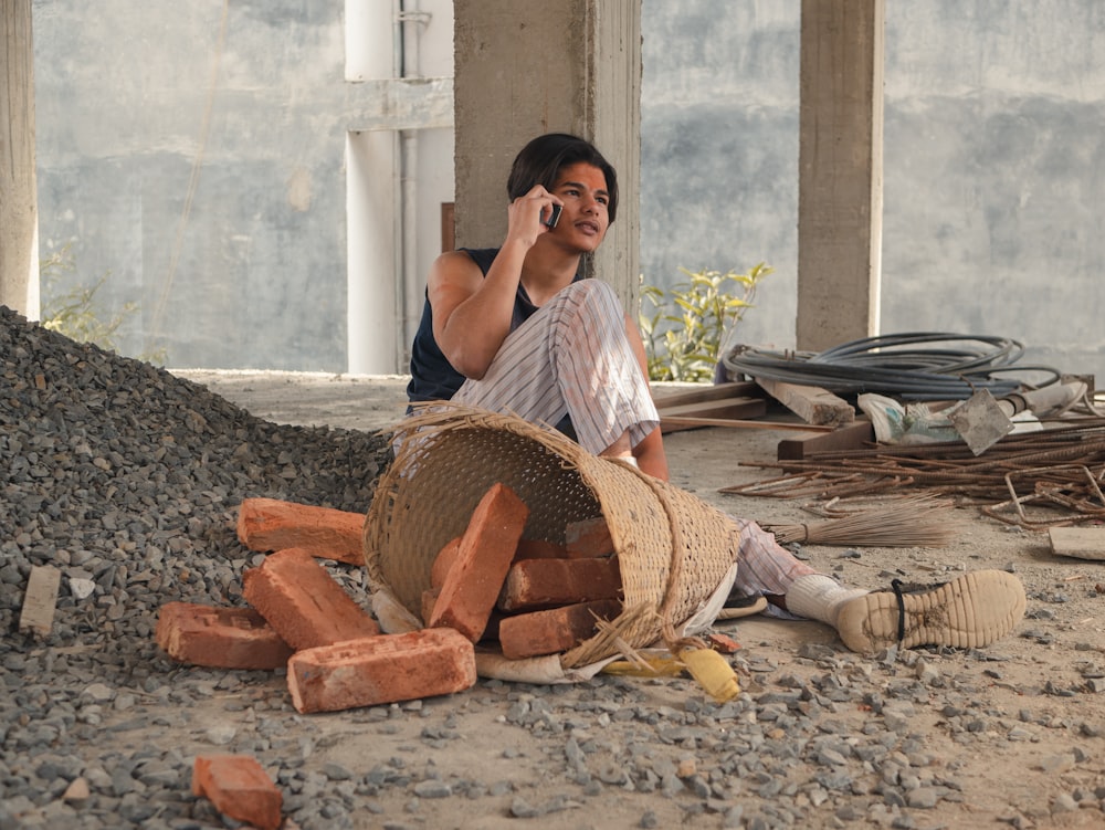 woman in white shirt sitting on ground with brown woven basket