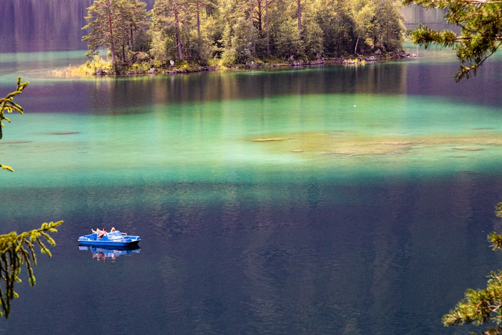 white and blue boat on body of water during daytime