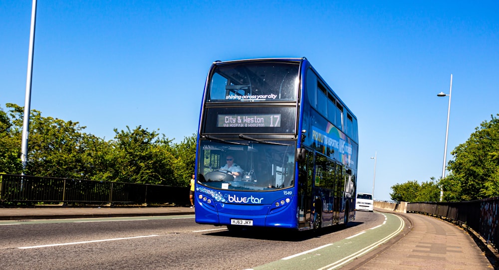 blue bus on the road during daytime