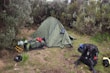 A collection of camping supplies set up in a natural environment.