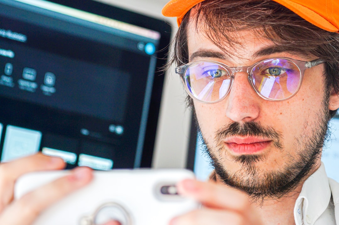 man in orange cap and black framed eyeglasses