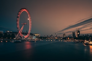 A clean, professional shot of the London Eye framed by subtle gold accents in the early evening.
