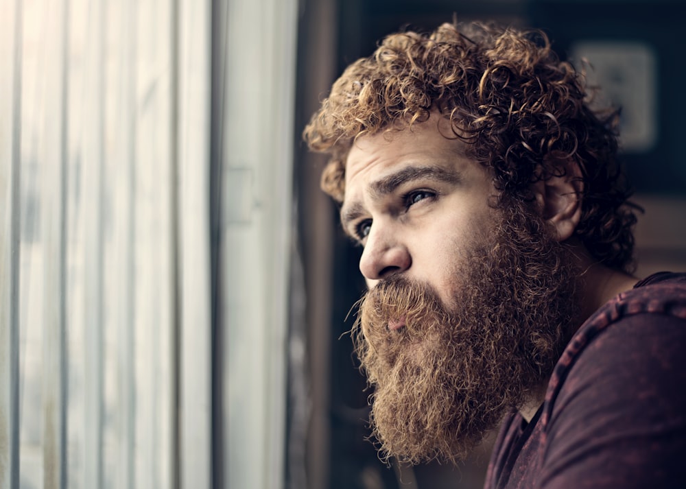 man in red shirt with brown curly hair