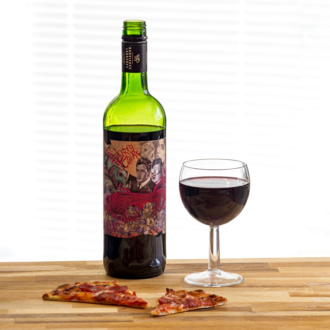 wine bottle beside wine glass on brown wooden table