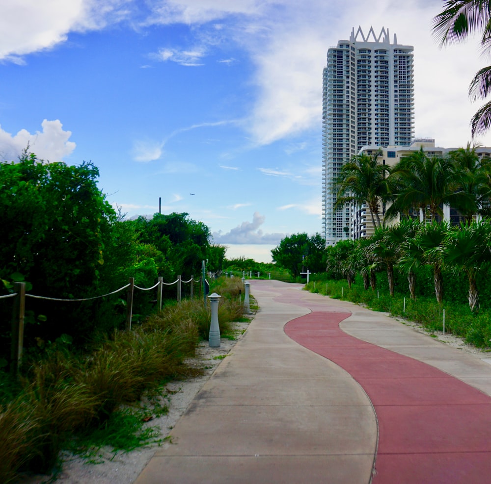 green grass field near trees and buildings under blue sky during daytime