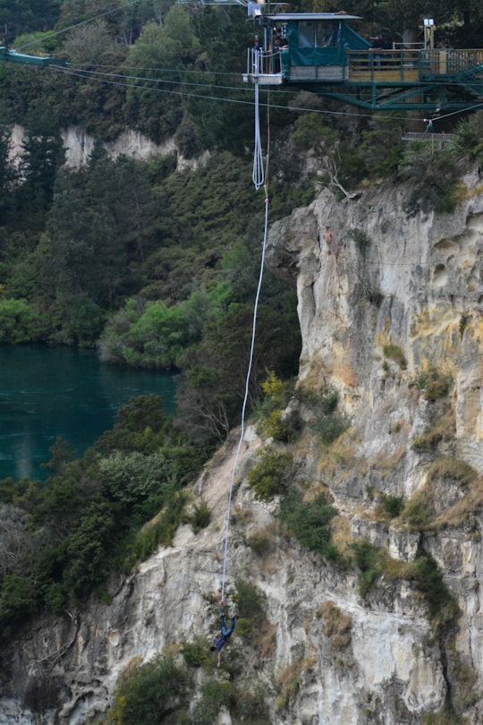 green trees on rocky mountain beside river during daytime in Lake Taupo New Zealand