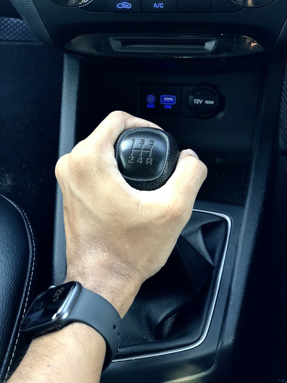person holding black car gear shift lever