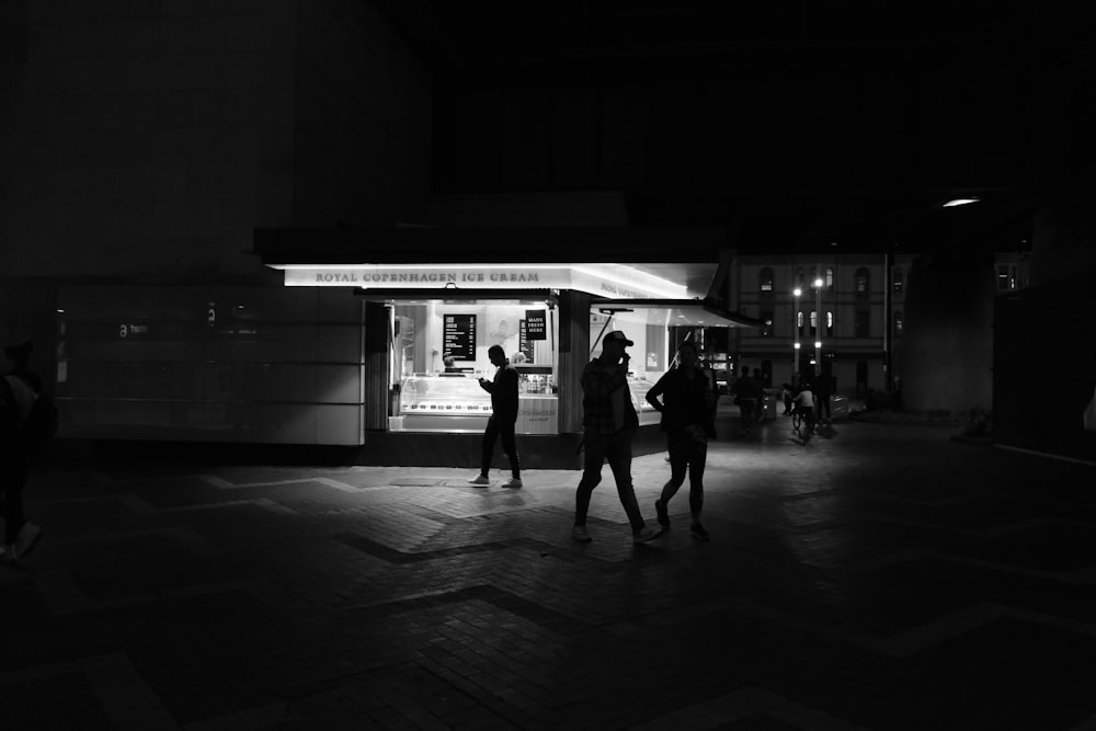 grayscale photo of 2 women walking on sidewalk