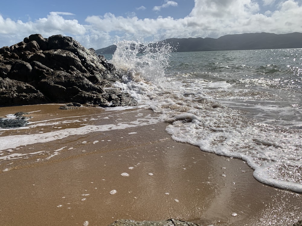 ocean waves crashing on shore during daytime