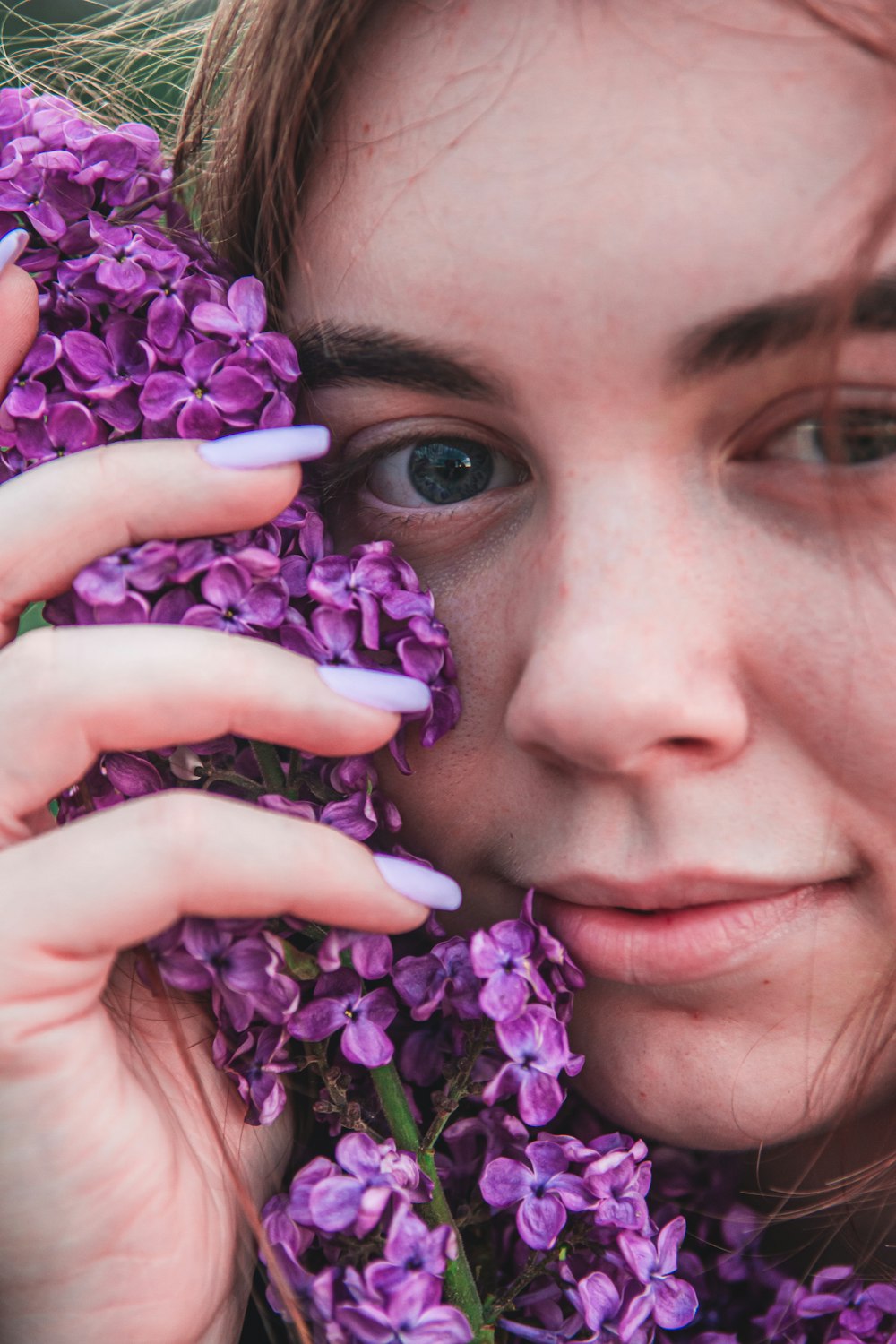 woman holding purple flower bouquet