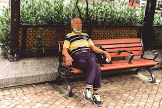 woman in blue and yellow stripe shirt sitting on brown bench
