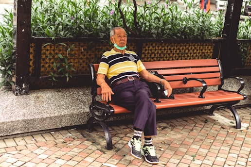 woman in blue and yellow stripe shirt sitting on brown bench