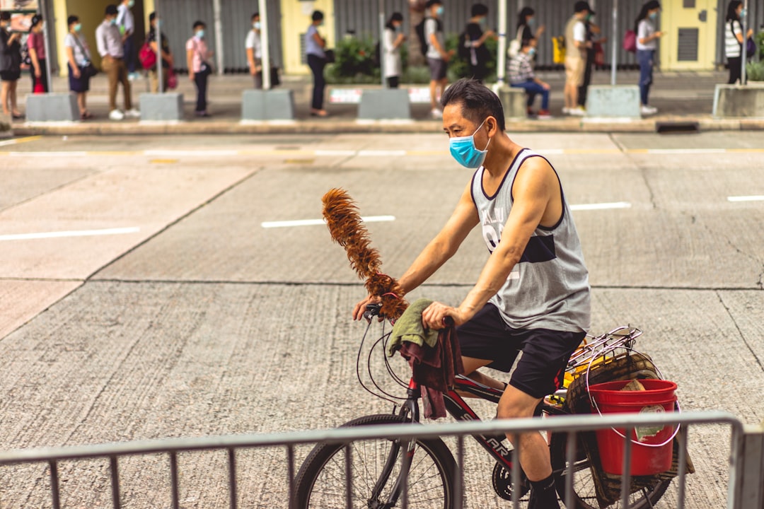 woman in white tank top riding bicycle during daytime