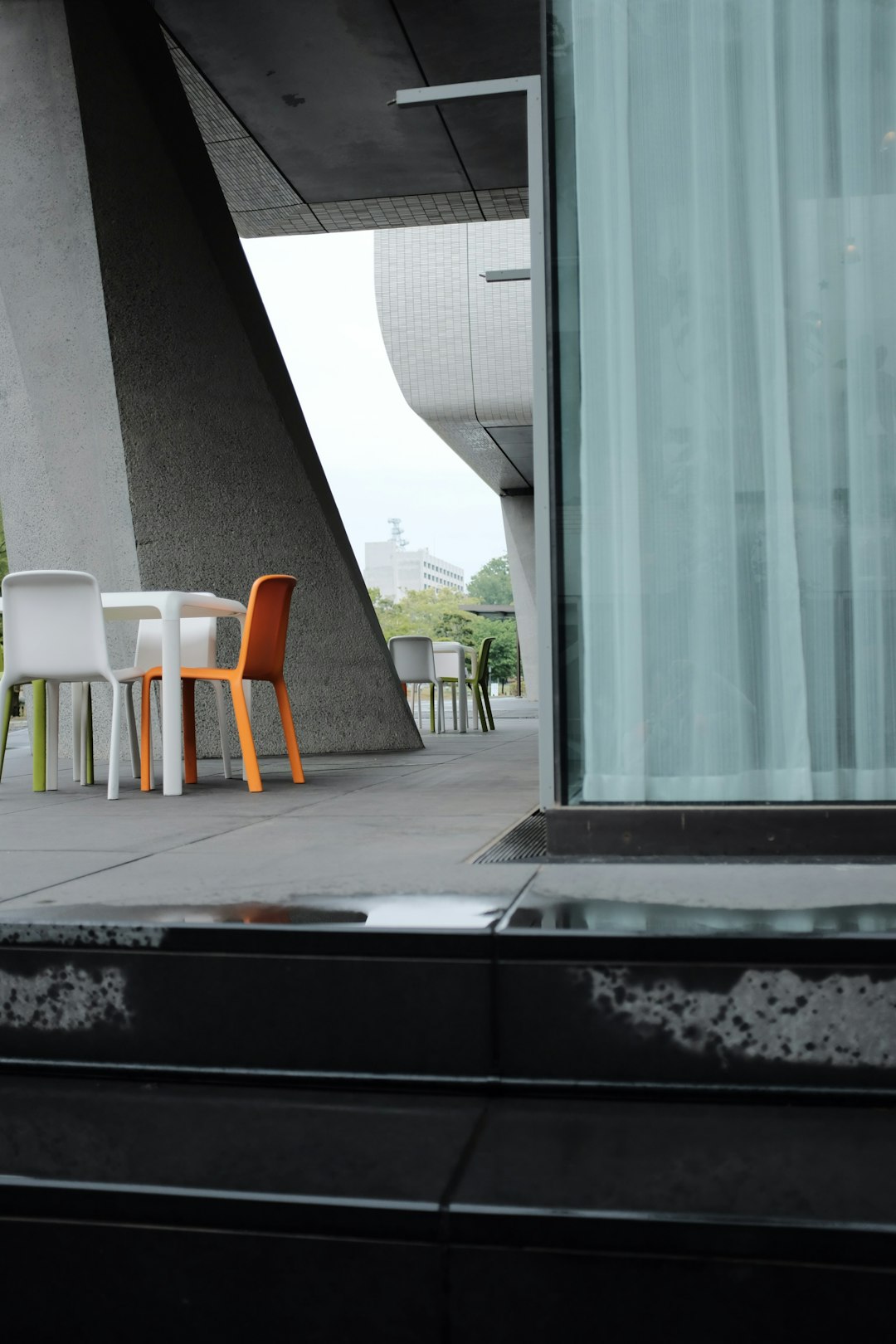 white plastic chair beside glass window