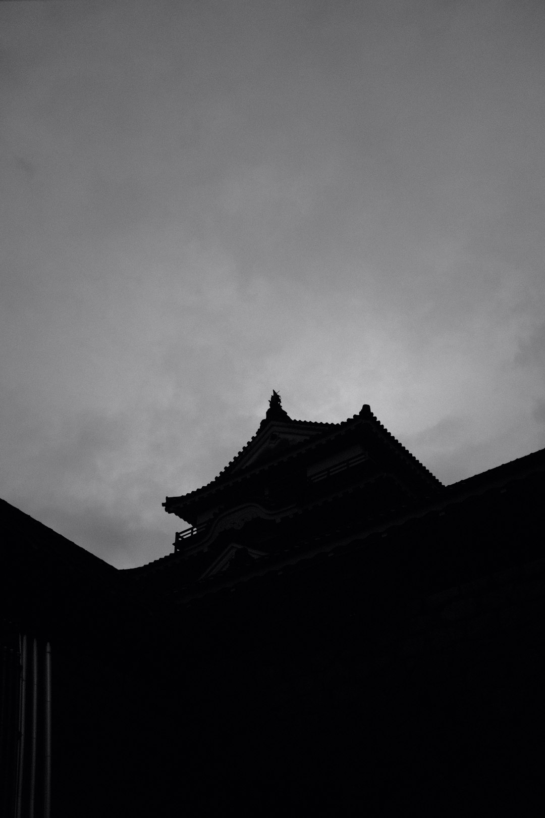 grayscale photo of temple under cloudy sky