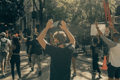 man in black t-shirt and black pants raising his hands black history teams background