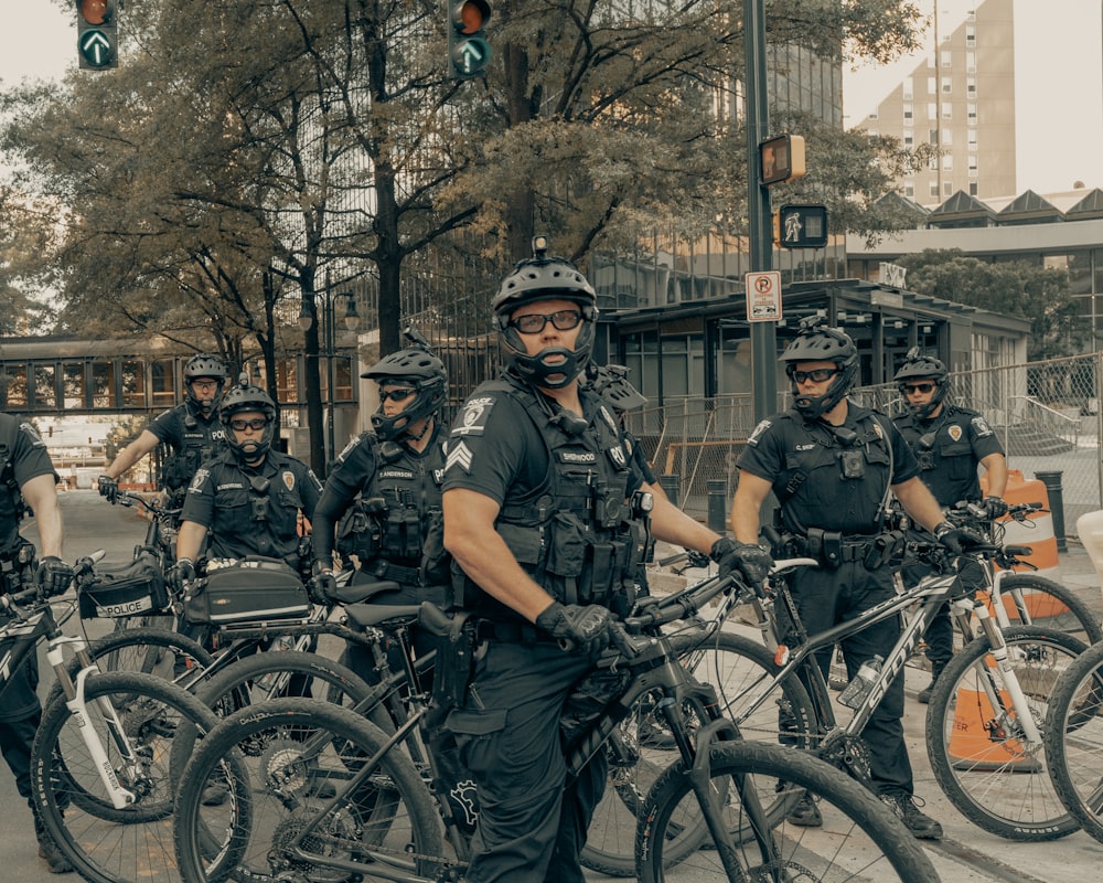 Hombres con uniforme de camuflaje negro y gris montando en bicicleta durante el día