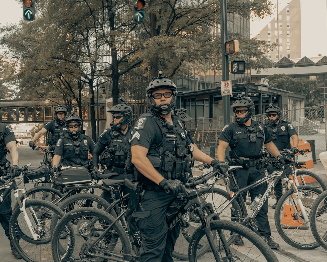 men in black and grey camouflage uniform riding on bicycle during daytime