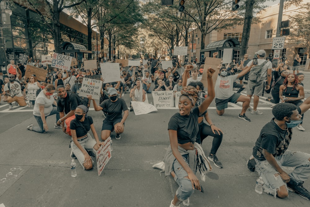 people sitting on gray concrete pavement during daytime