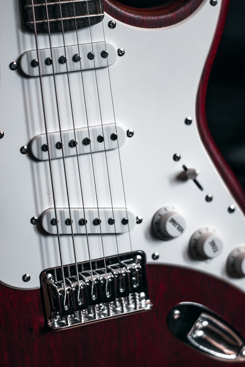 red and white stratocaster electric guitar