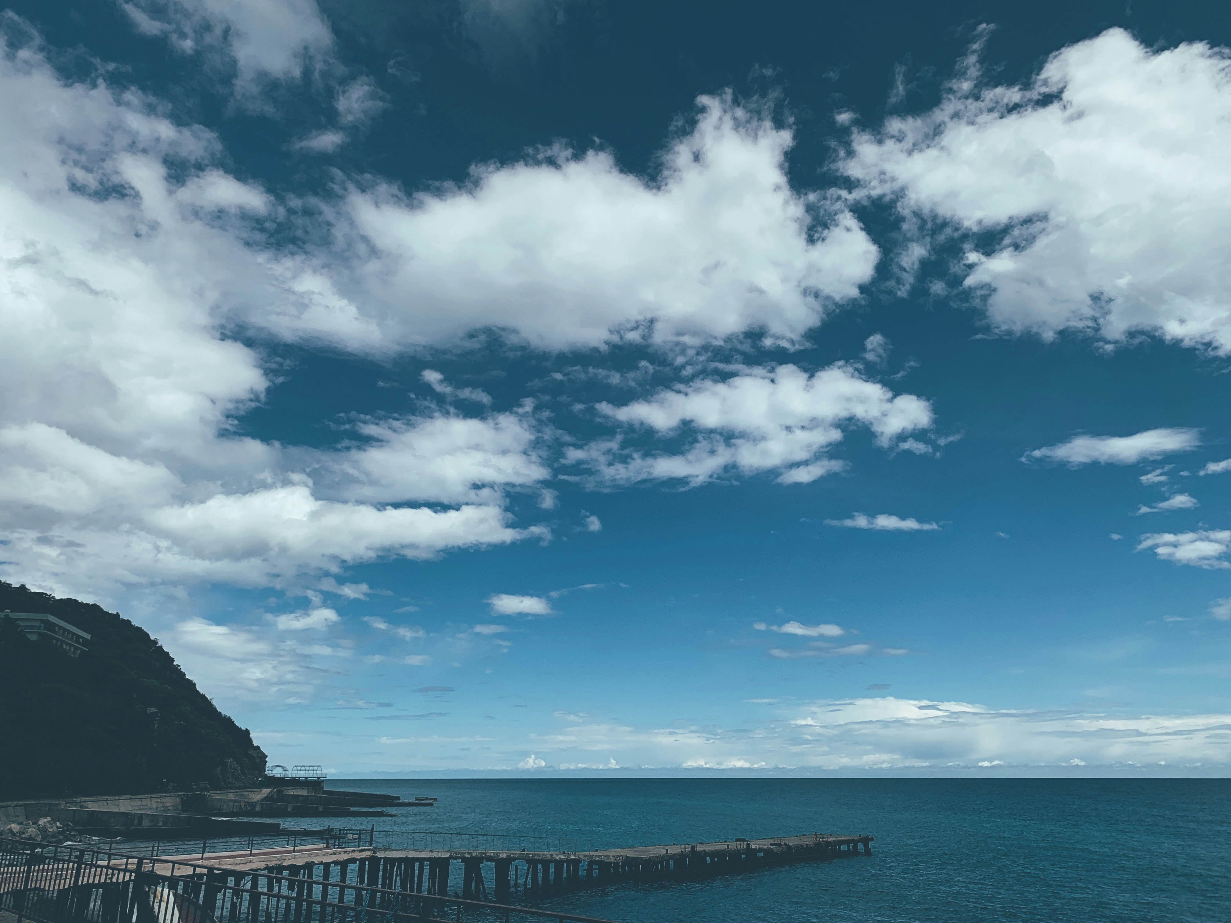 Blue sky and white clouds over sea photo – Free Blue Image on Unsplash