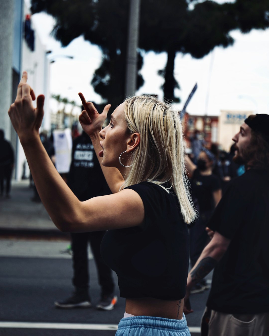 woman in black shirt standing on street during daytime