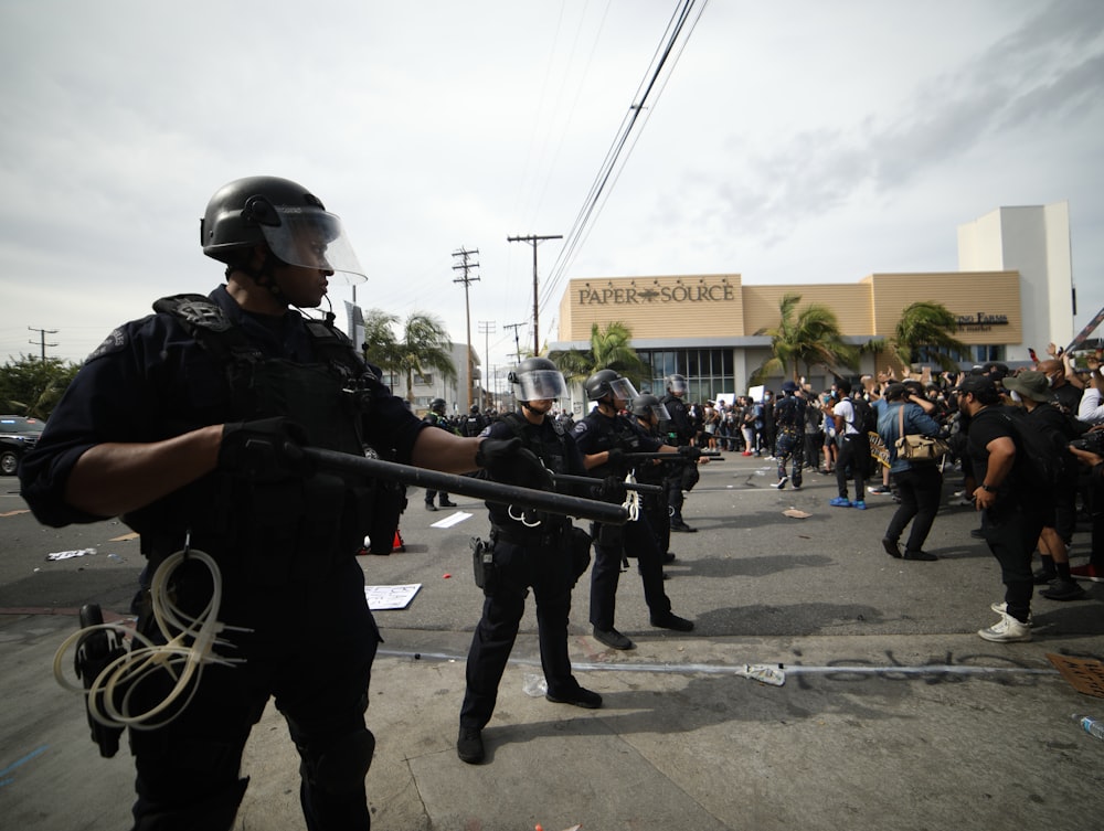 Hombre con chaqueta negra sosteniendo un rifle negro