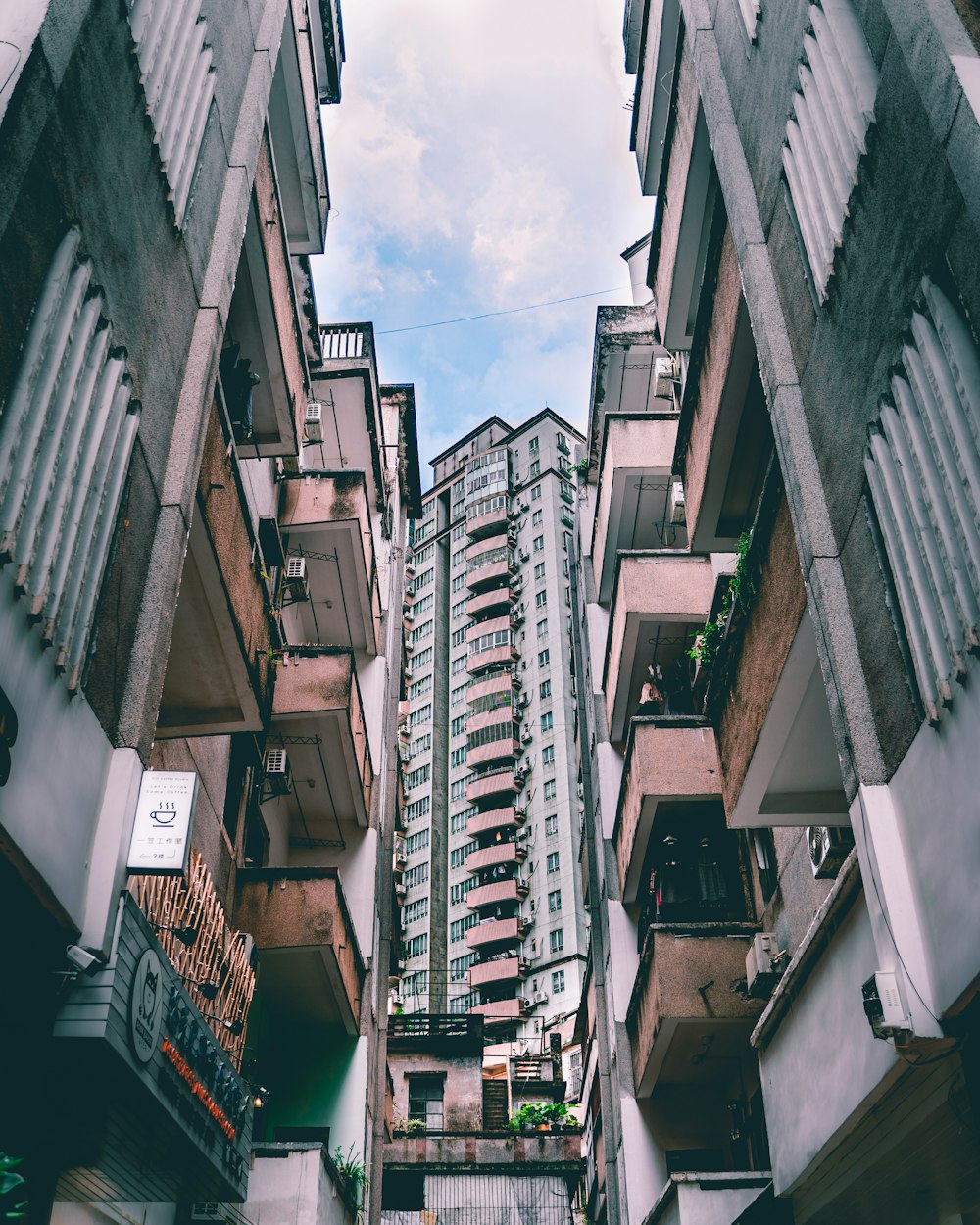 low angle photography of high rise buildings under white clouds during daytime